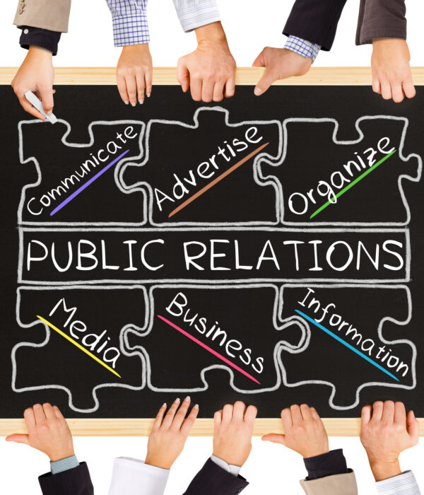 Photo of business hands holding blackboard and writing PUBLIC RELATIONS diagram