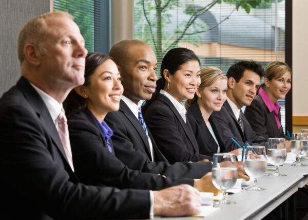Multi-ethnic co-workers sitting in a row at conference table
