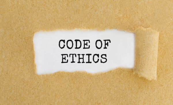 Text Code Of Ethics appearing behind ripped brown paper.