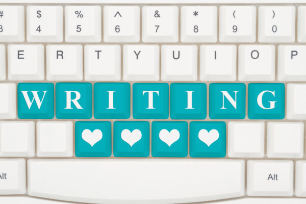 Love writing on the internet, A close-up of a keyboard with teal highlighted text Writing and hearts